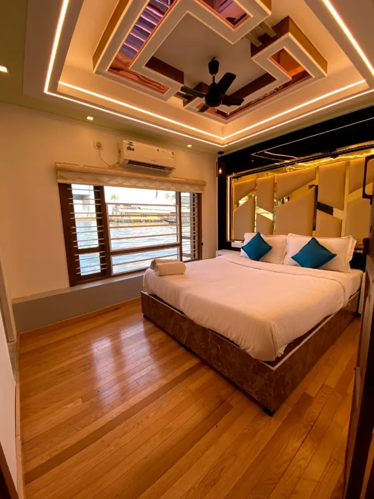Private air-conditioned bedroom with double bed and viewing windows on RIV01 premium houseboat in Alleppey