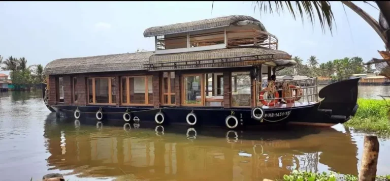 Side exterior profile of Queens premium houseboat BNU01 showing the private upper deck and backwater scenery
